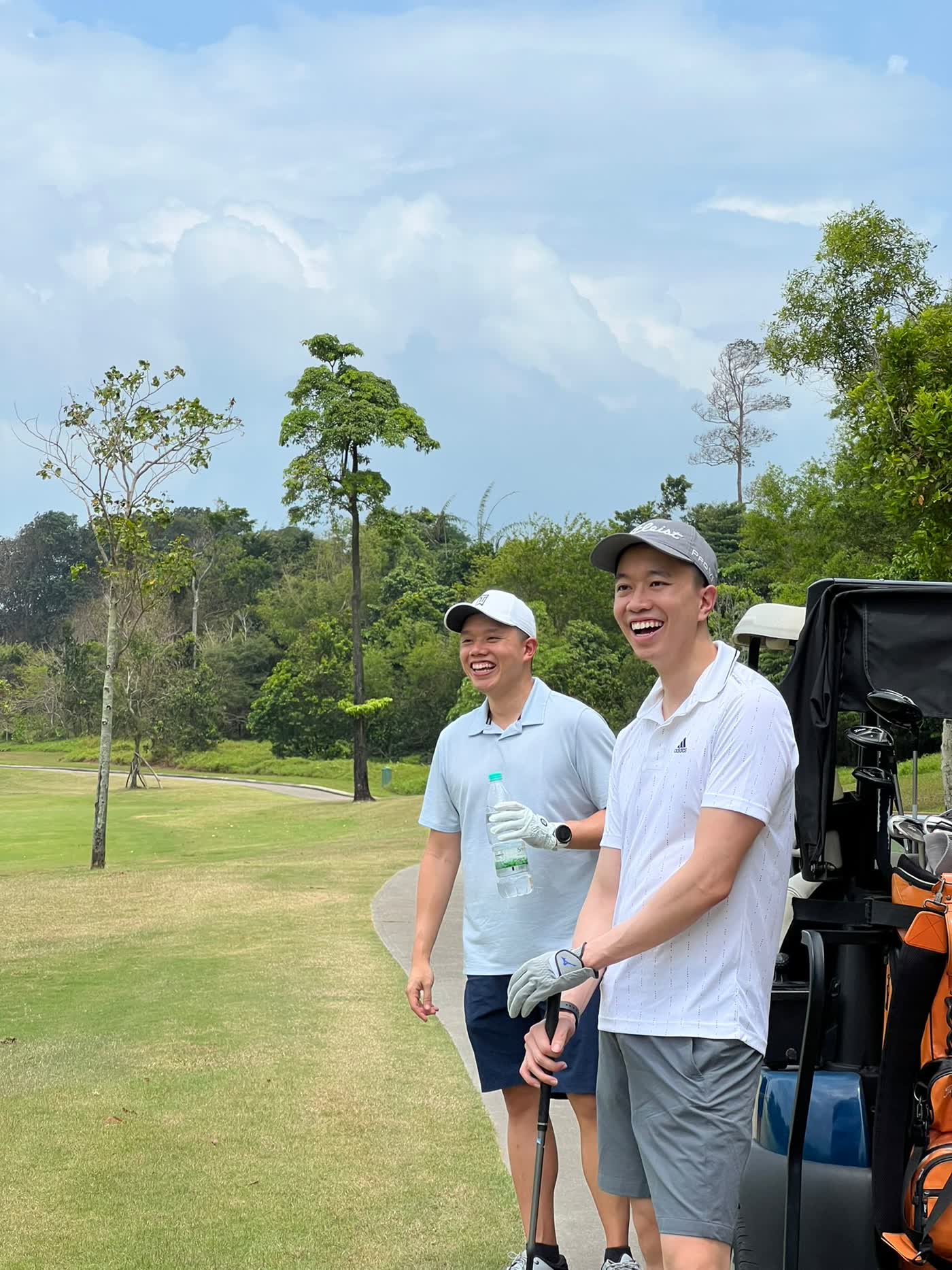 Felix and a playing partner on the course, laughing beside the cart
